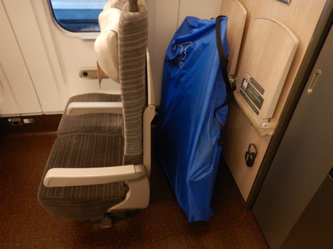 新幹線最後部の荷物起きスペースに輪行袋を置く